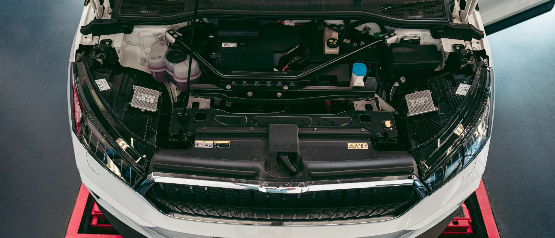 Elektroauto mit offener Motorhaube bei der Hauptuntersuchung durch GTÜ-prüfingenieur bei Hett und Hemm