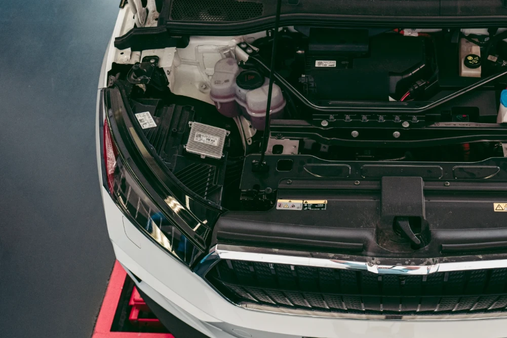 Elektroauto mit offener Motorhaube bei der Hauptuntersuchung